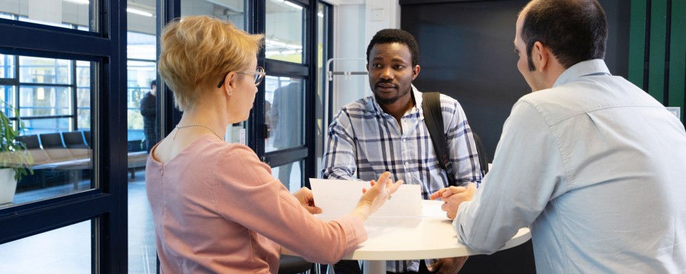 Kolme henkilöä keskustelee.