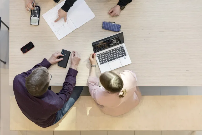 People of different genders working at the same table