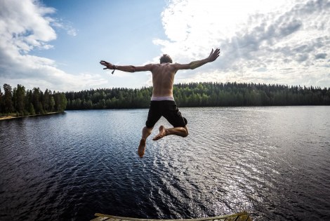 Henkilö hyppäämässä kesäiseen järveen