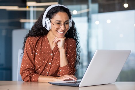 Nainen, kuulokkeet, tietokone